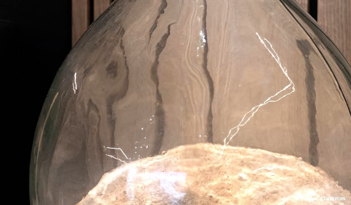 Gros plan d'une grande bonbonne décorative en verre.