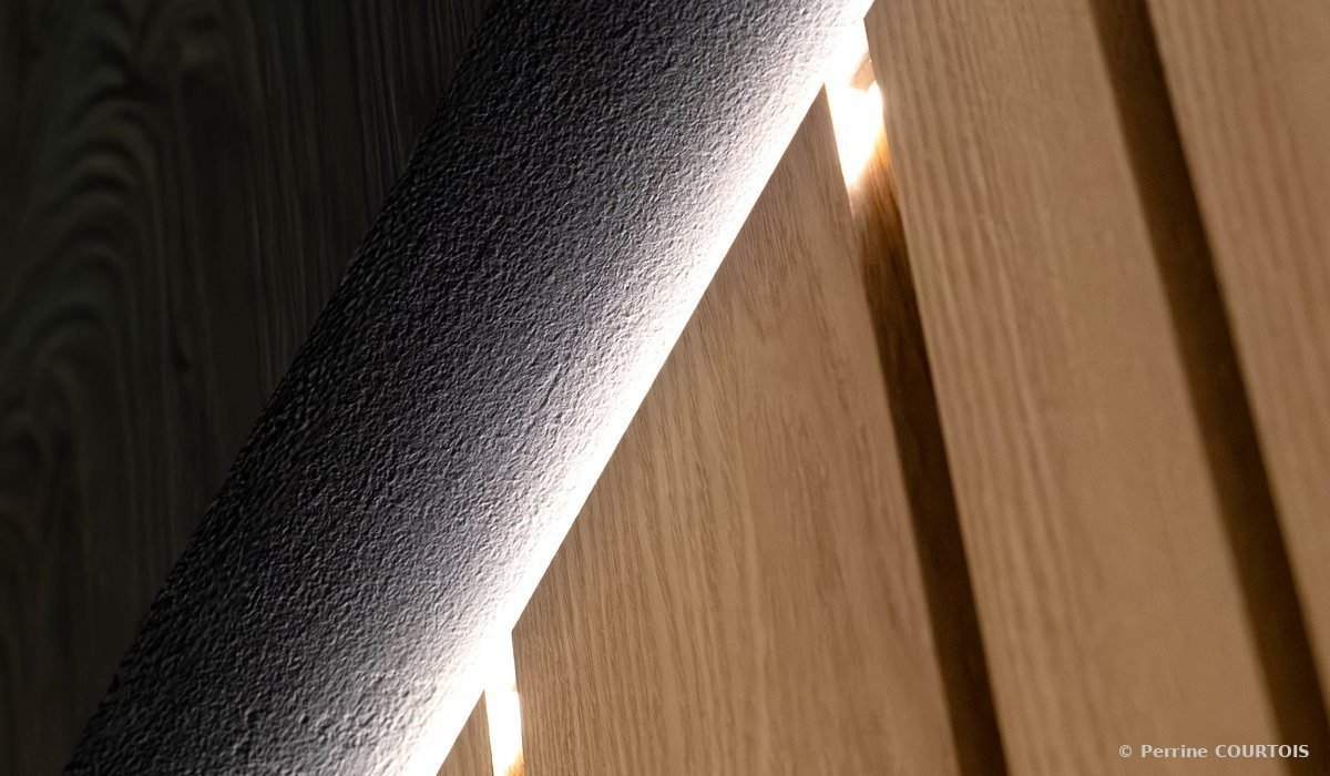 Tasseaux de bois éclairés par un ruban lumineux, avec un élément noir texturé au premier plan.