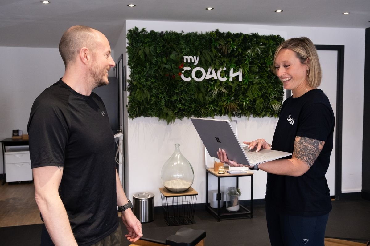 Une coach fait le point avec un adhérent, ordinateur en main, au studio de Marcq-en-Barœul.