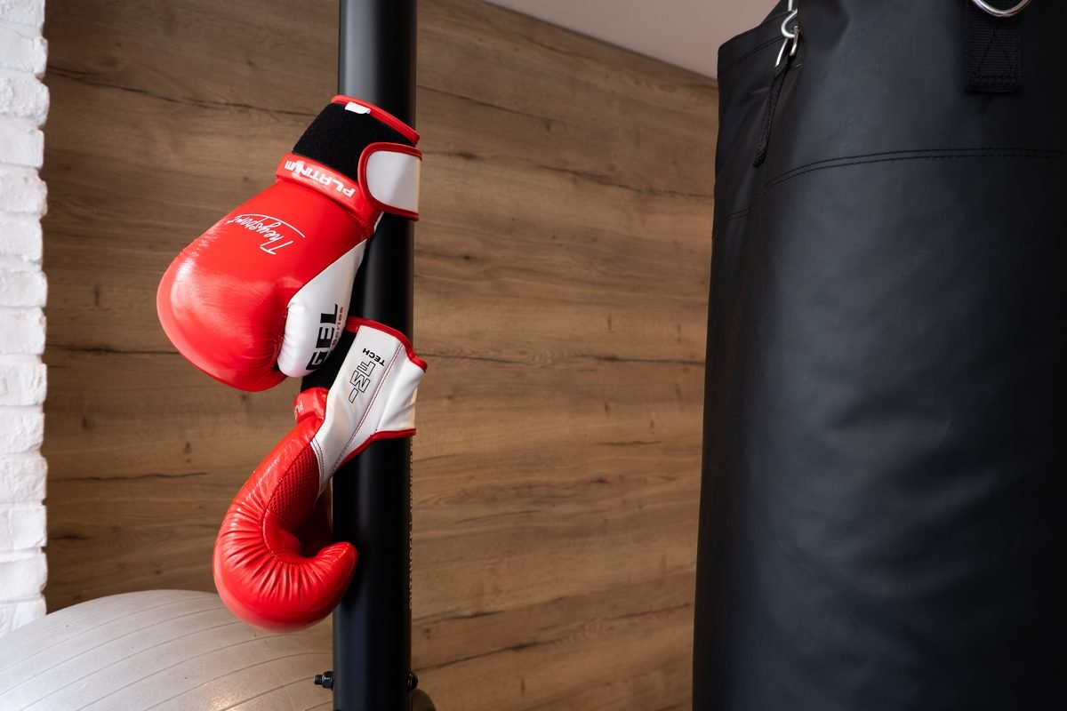 Des gants de boxe rouges accrochés près du sac de frappe, au studio de Neuilly-sur-Seine.