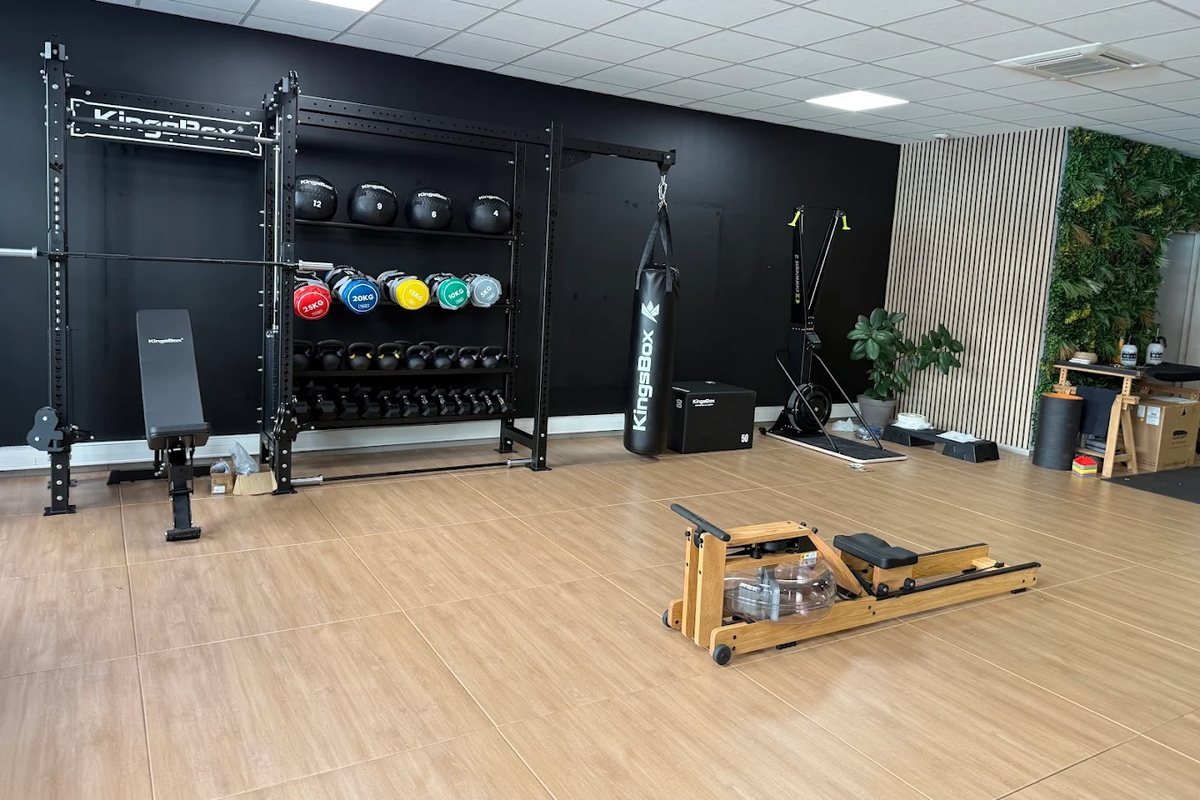 L'espace d'entraînement du studio My Coach de Valence : rack, médecine-balls, kettlebells, sac de frappe et rameur en bois.