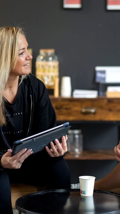 Une coach échange avec une adhérente, tablette en main, au studio My Coach de Wasquehal.